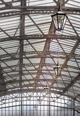 Windsor, İngiltere - Nisan 03, 2025 Windsor Kraliyet Alışveriş Kompleksi 'nin tavanında lambalar olan klasik cam çatı. Metalik çerçeve çatısı, tavan lambası, Viktorya dönemi mimarisi. Duvar kağıdı olarak kullan, P