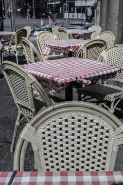 Newcastle, İngiltere - 13 Nisan 2025 - Sıralar dolusu boş masa ve kırmızı beyaz masa örtülü sandalyeler ve caddedeki bir kafe önünde sandalyeler. Öğleden sonra Outdoor yazlık kafe manzarası, bunu metin için duvar kağıdı, poster ve boşluk olarak kullanın.
