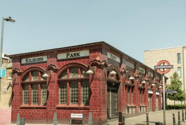 Londra, İngiltere - 12 Temmuz 2025 - Londra Brent İlçesi 'ndeki Kilburn Park Yeraltı İstasyonu' nun ayırt edici bir İngiliz Art Nouveau mimarisi, dış bina camlı ve öküz kanı kırmızısı camlı yuvarlak kaplaklar içeriyor.
