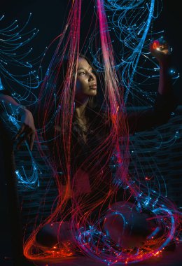Bangkok, Tayland - 13 Aralık 2025 - enerjik fiber optik ışıklar bir kadını zarifçe sarar, çarpıcı ve dramatik bir fotoğraf efekti yaratır.