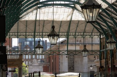 Londra, İngiltere - 13 Mayıs 2025 - Covent Garden Market Salonunda tavan arasında asılı demir cam çatı ve Fenerler ile mimari Greko-Romen tarzı. Metalik çerçeve kemer çatı manzarası tavan lambası asılı, bunu duvar kağıdı olarak kullanın, poster.