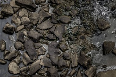 Demiryolu raylarında motor yağıyla ıslanmış balast taşı çakıl taşları..