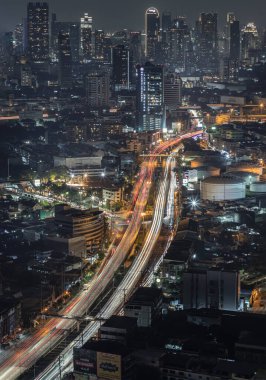 Bangkok, Tayland 20 Aralık 2024 - Günbatımından sonra parlayan ışıklarla gece manzarası. Bangkok yolundaki arabaların gece görüşü, ışık eğrileri için uzun pozlama, metin için duvar kağıdı, poster ve boşluk olarak kullanın.