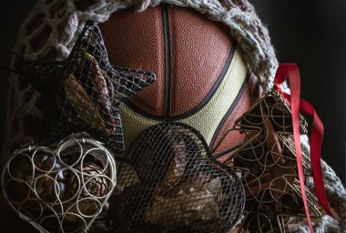 İçinde ağ örgüsü süslemesi olan basketbol topu, Noel ağacı örgüsü davası, ve karanlık arka planda Star Ağ davası. Noel temalı basketbol fikri, Noel 'de spor oyunu, Duvar kağıdı, Poster ve Uzay olarak kullanın..