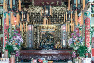 Muhtemelen Mazu 'ya adanmış bu geleneksel Çin tapınağının görkemli iç mabedi derin bir saygı atmosferi sergiliyor. Sahne, karmaşık heykellerin parıldayan altınlarıyla vurgulanmış kutsal bir dinginliği yakalar..