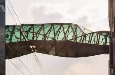 Geometrik tasarım ustası Tottenham Hotspur 'daki gökyüzü köprüsünün karmaşık kıvrımları işlevsel altyapıyı konsept estetiğiyle kusursuz bir şekilde harmanlıyor. Köprü, kulüp faaliyetleri için hem gerçek hem de mecazi bir göbek bağı görevi görüyor.