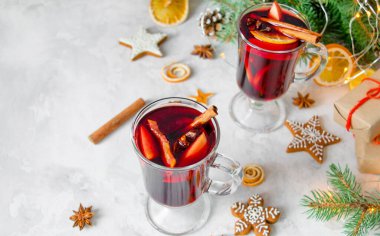 Noel 'in en güzel manzarası karanfilli sıcak şarap, tarçın, kakule ve açık gri arka planda Noel süslemeleri ile anason. Yeni yıl içkileri.