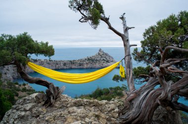 Arka planda dağlar ve deniz var. Novyi Svit, Kırım, Sudak. Kapchik adında bir pelerin, Karadeniz. Dağlar, deniz, orman manzaralı güzel bir manzara..