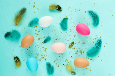 Pastel mavi arka planda renkli yumurtalarla Paskalya arkaplanı.