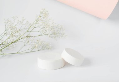 Ürün sunumu için arka plan modeli. Somut podyum ve arka planda beyaz çiçekler olan dal.