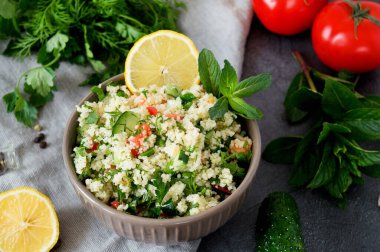 Geleneksel oryantal salata Tabouleh kuskus veya bulgur ile adark beton arka planda. Salata için malzemeler: dereotu, maydanoz, domates, salatalık, kuskus..
