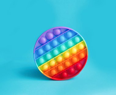 Yeni popüler anti-strese karşı mavi arka plandaki çocuklar için bir oyuncak. Ön tarafa bak. Uzayı kopyala. Pankart.