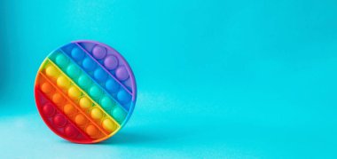 Yeni popüler anti-strese karşı mavi arka plandaki çocuklar için bir oyuncak. Ön tarafa bak. Uzayı kopyala. Pankart.