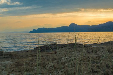 Deniz ve dağ manzaralı güzel bir gün batımı. Sudak şehri, Kırım, Cape Meganom. Kapsel Vadisi 'ne ve Meganom Burnu' na doğru Manzaralı Panoramik Manzara.