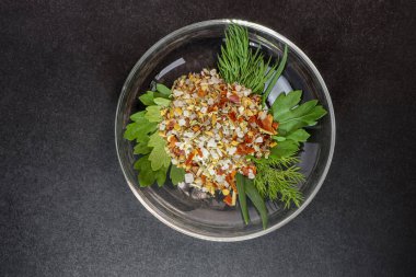 Taze otlu baharatlar ve kaba deniz tuzu tabakta. Siyah arkaplan.