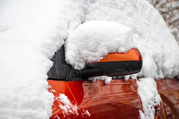 Snow-covered frozen car covered with snow. Winter road. Danger of winter driving. Car snow removal. Dangerous traffic situation.