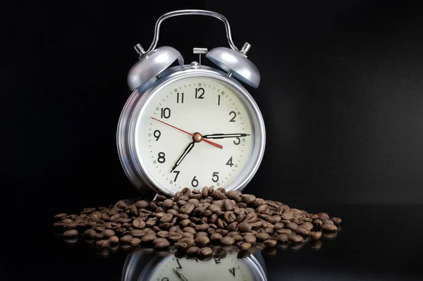 Scattered coffee beans, classic alarm clock. Morning coffee day start. Concept for advertising. Time to drink coffee