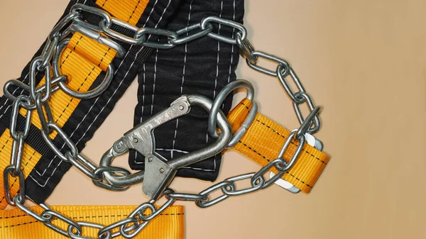 Safety belt for work at height with carabiner. Professional safety equipment for mountaineering and construction. Safety precautions. Close-up