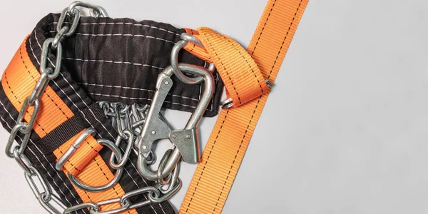 Safety belt for work at height with carabiner. Professional safety equipment for mountaineering and construction. Safety precautions. Close-up