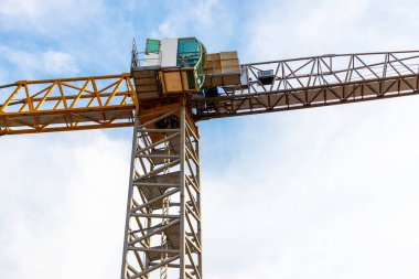 Mavi gökyüzünün arka planında bir vinç var. Modern konut inşaatı. Endüstri mühendisliği. Konut kredisi inşaatı