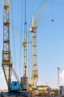 Günbatımı gökyüzünün arka planına karşı kule vinçlerinin çalışması. Modern konut inşaatı. Endüstri mühendisliği. Konut kredisi inşaatı