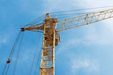 Mavi gökyüzünün arka planında bir vinç var. Modern konut inşaatı. Endüstri mühendisliği. Konut kredisi inşaatı