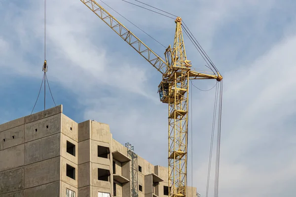 A tower crane assembles gutter panels during the construction of a panel house. Modern housing construction. Industrial engineering. Construction of mortgage housing