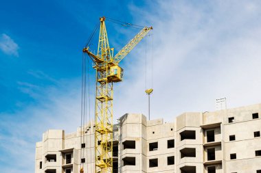 Günbatımı gökyüzünün arka planına karşı kule vinçlerinin çalışması. Modern konut inşaatı. Endüstri mühendisliği. Konut kredisi inşaatı