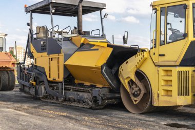 Asfalt kaldırım ekipmanları. Asfalt kaldırım taşı ve ağır titreşimli silindir. Yeni yollar ve yol kavşaklarının inşaatı. Ağır inşaat endüstriyel makineleri