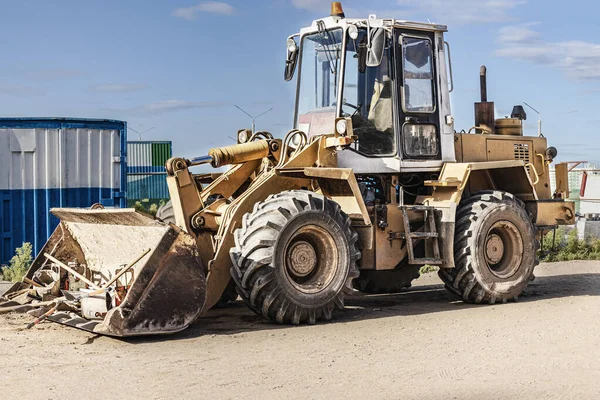 Heavy front loader on a construction site with a construction tool in the bucket. Equipment for earthworks, transportation and loading of bulk materials - earth, sand, crushed stone