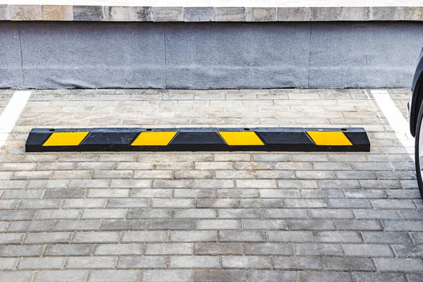 Arabalar için sarı park yerlerinin olduğu bir yerleşim bölgesinde boş bir otopark. Yakın plan. Park Limiter 'ını Durdur