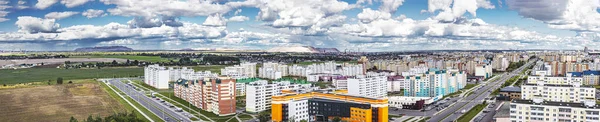 Panoramic view of the industrial city against the backdrop of a blue cloudy sky. In the background are large mines and waste heaps. Belarus. Soligorsk. 2021