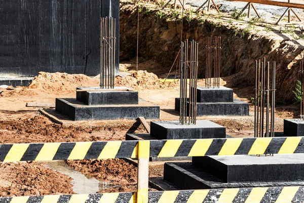 Monolithic reinforced concrete foundations for the construction of a residential building. Grillage at the construction site. Construction pit with foundations