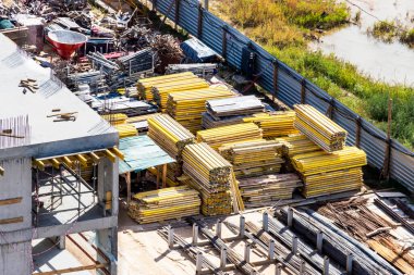 İnşaat alanında malzeme ve malzeme deposu. Monolitik bir evin inşası için hazırlanan yapı elemanları ve yapı malzemeleri