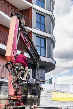 Yükleyici vinci olan bir makine kamyonu bir ev inşa etmek için blokları boşaltıyor