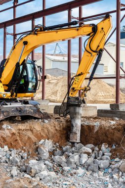 Endüstriyel hidrolik çekiç ve kazıcı kullanılarak güçlendirilmiş beton yapıların profesyonel yıkımı. Metal alaşımlı çubuklar. Beton enkazı ve kırıntıları
