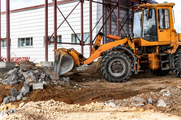 建筑工地的前端装载机清除钢筋混凝土的碎片 收集及移走拆开的建筑材料 — 图库照片