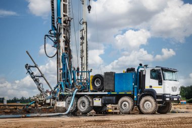 Sondaj kulesi bulutlu gökyüzünün arka planına karşı bir kuyu açıyor. Derin kuyu kazmak. Jeolojik araştırmalar. Mineral keşfi. Güçlü matkaplar kuyuyu kazar