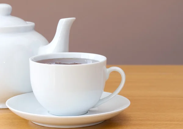 Kopje thee met theepot op een tafel — Stockfoto