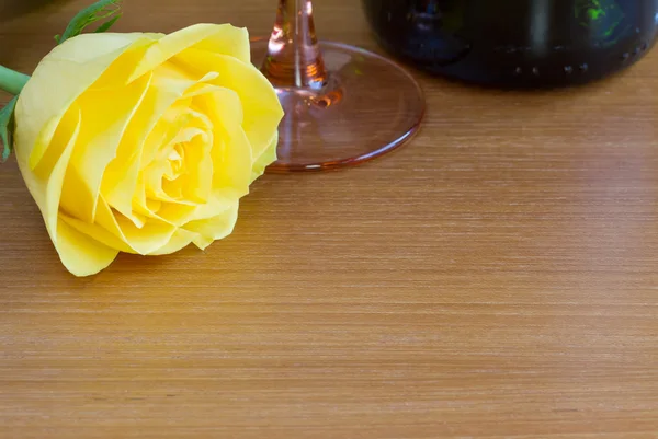 Yellow rose with a bottle of wine and a glass