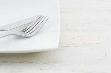 Eski püskü bir beyaz masada beyaz yer ayarı