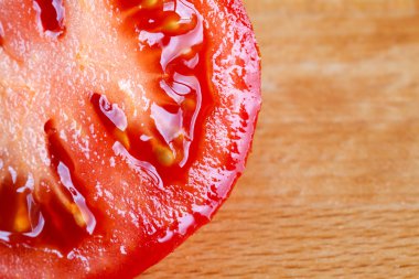 Bir ahşap tahta üzerinde kırmızı ripe domates dilim