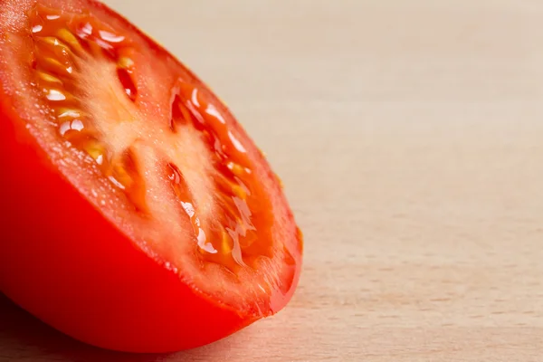 La moitié d'une tomate mûre rouge sur une planche de bois — Photo
