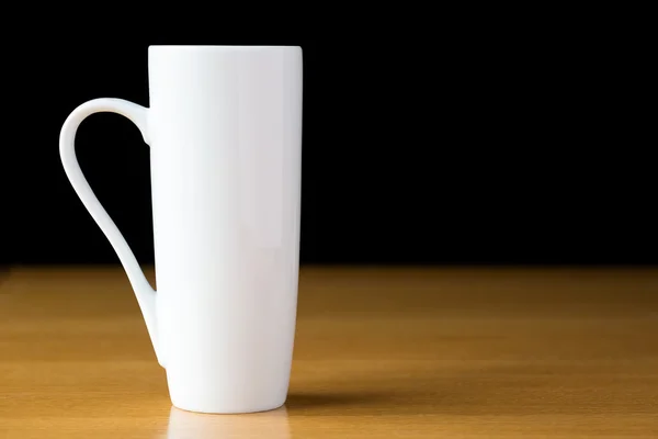 Tall white mug on a wooden table — Stock Photo, Image