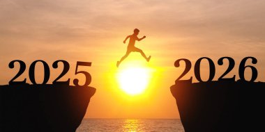 Yeni Yıl 2026, ilham ve yeni başarı yolunda ilerleme. 2025 sayısıyla bir uçurumdan atlayan insanların silueti 2026 numaralı yeni yıl hedeflerine ve meydan okuma konseptine doğru ilerliyor.