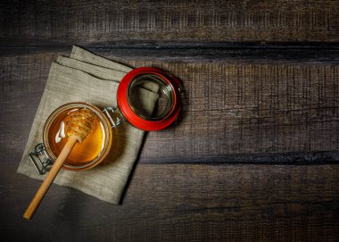 Tahta arka planda kavanozda bal