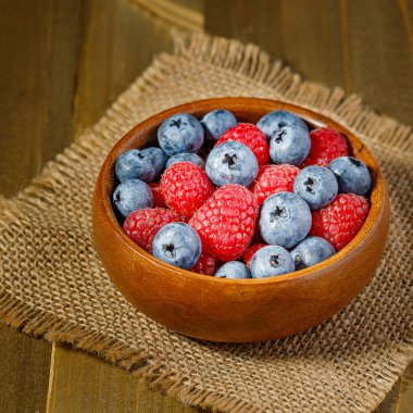 Tahta kasede taze yaban mersini ve ahududu yanında süt ve yoğurt.