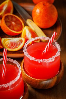 Tahta arka planda Sicilya kan portakalları. Buzlu ve portakal dilimli kan portakal suyu..