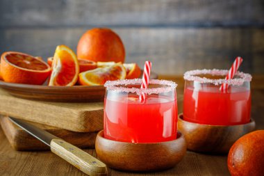 Tahta arka planda Sicilya kan portakalları. Buzlu ve portakal dilimli kan portakal suyu..