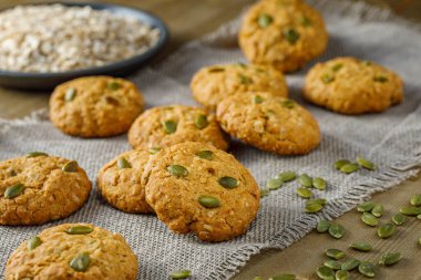 Kuru üzümlü ev yapımı yulaflı kurabiyeler ve ahşap zemin üzerinde ayçekirdeği.